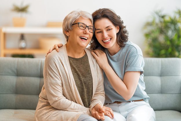beautiful mother daughter talking smiling while sitting couch home beautiful mother daughter talking smiling while sitting couch home