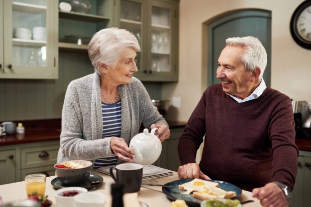 Youre my favorite cup of tea. an affectionate senior couple drinking tea and having a meal together in the kitchen at home.