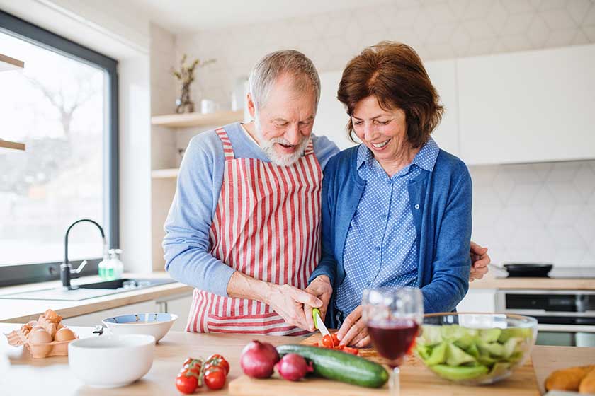 A portrait of senior couple in love indoors at home cooking A portrait of senior couple in love indoors at home cooking