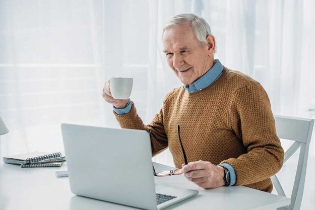 Senior confident man working on laptop and hold