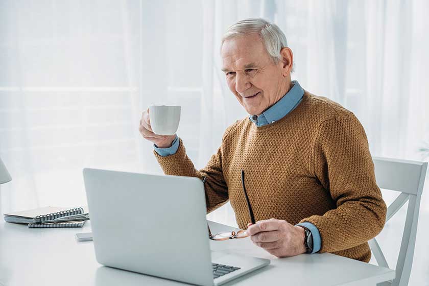 Senior confident man working on laptop and hold