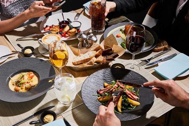 Cropped view people eating delicious food restaurant Cropped view people eating delicious food restaurant