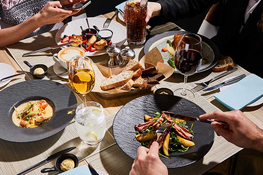 Cropped view people eating delicious food restaurant