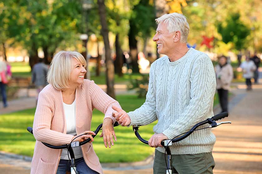 cute elderly couple with bicycles in autumn park