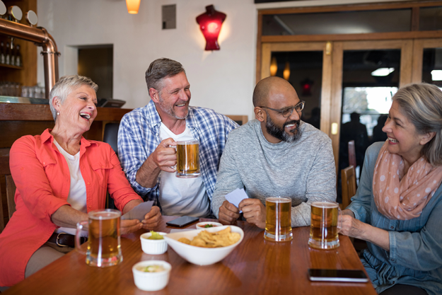 Friends interacting while having beer and snacks