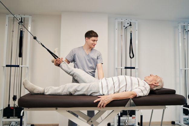Person doing leg exercise with foot attached to resistance band Person doing leg exercise with foot attached to resistance band