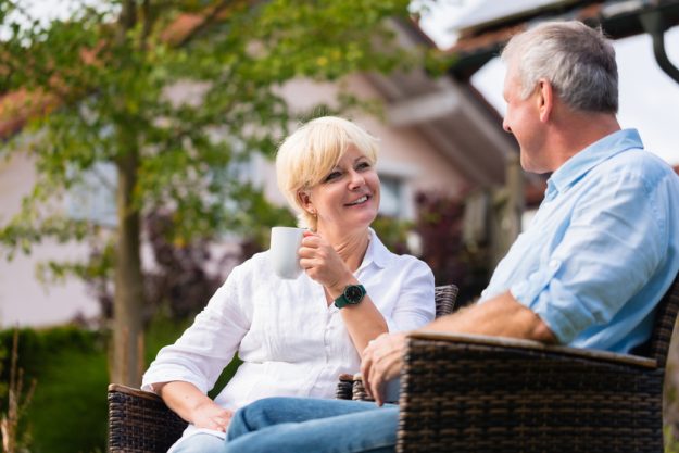 Senior man and woman sitting in front of house Senior man and woman sitting in front of house
