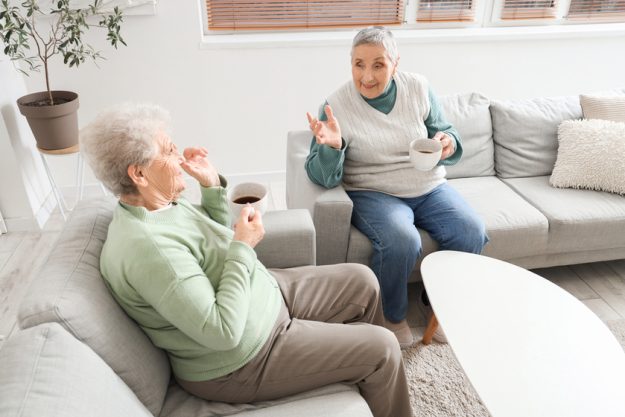 Senior female friends drinking tea at home