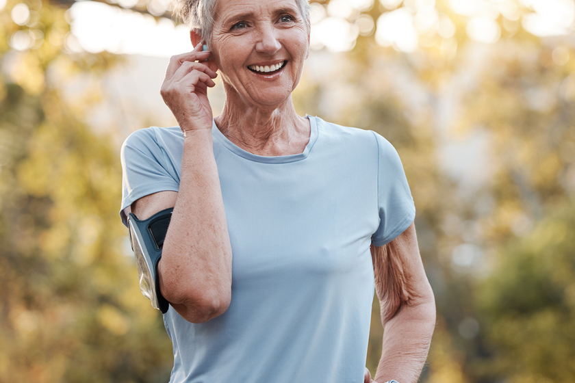 Senior woman, run outdoor and happy with music or audio podcast for lifestyle motivation, runner fitness and exercise workout. Elderly athlete, smile and training or running rest in nature park Senior woman, run outdoor and happy with music or audio podcast for lifestyle motivation, runner fitness and exercise workout. Elderly athlete, smile and training or running rest in nature park