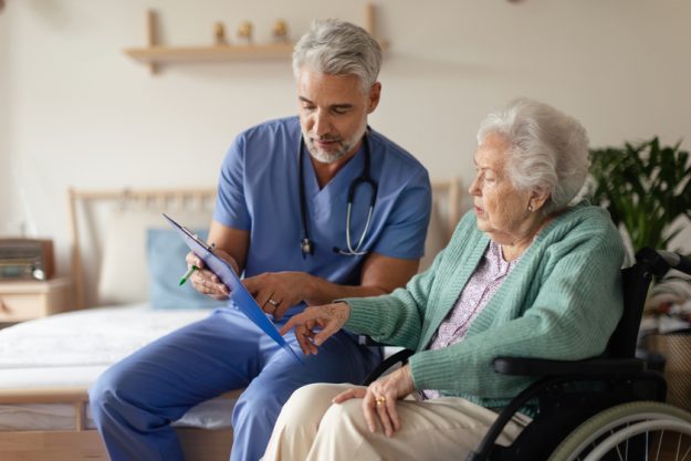 Caregiver doing regular check up of senior woman in her home. Caregiver doing regular check up of senior woman in her home.