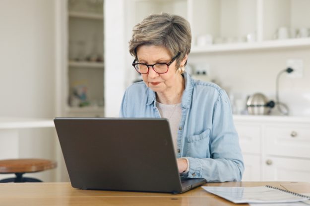 Home, laptop and senior woman reading website for asset management services, registration or planning retirement. Elderly person on computer of pension research, funding application or life insurance