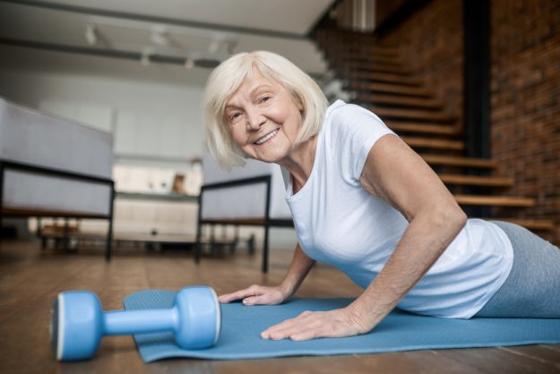 Senior active woman in a white tshirt doing plank Senior active woman in a white tshirt doing plank