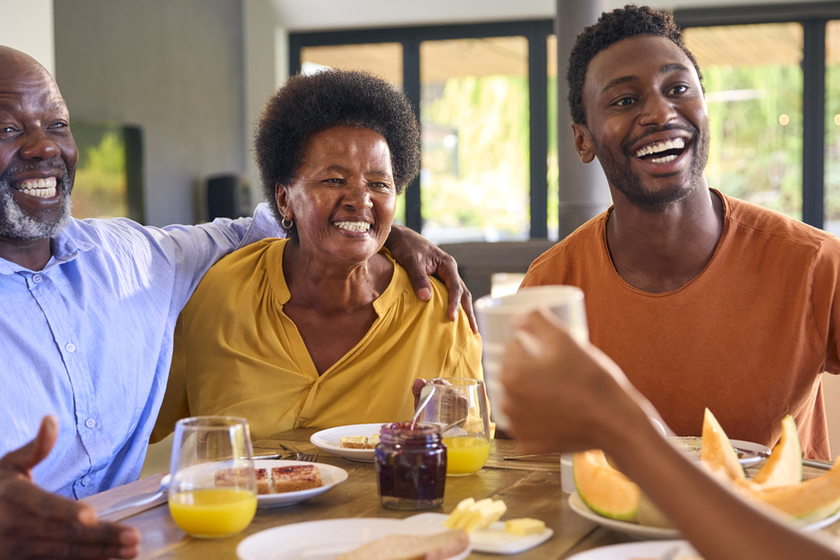 Family Shot With Senior Parents And Adult Offspring At Breakfast Around Table At Home Family Shot With Senior Parents And Adult Offspring At Breakfast Around Table At Home