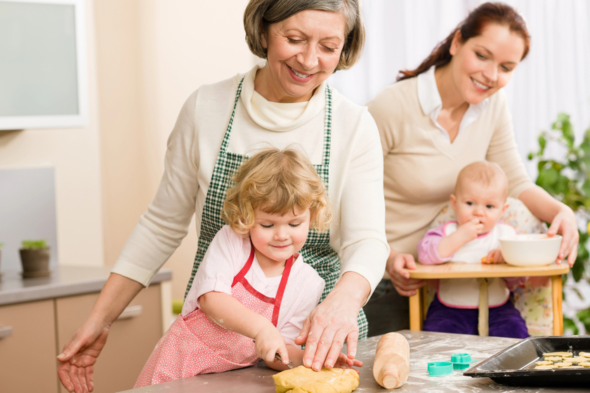 Grandmother with little girl prepare dough for baking in kitchen Grandmother with little girl prepare dough for baking in kitchen