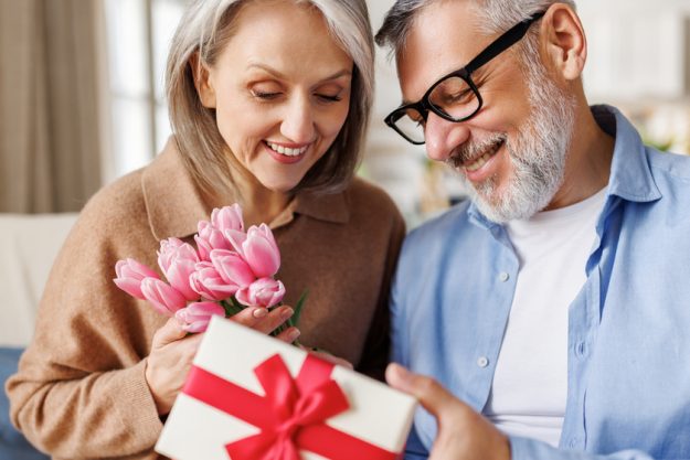 Romantic senior man congratulating happy wife on Valentines Day at home Romantic senior man congratulating happy wife on Valentines Day at home