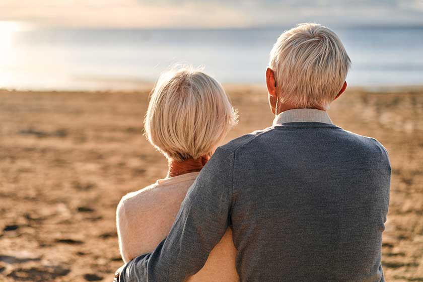 Elderly intelligent gray haired couple love sitting sun lounger seashore