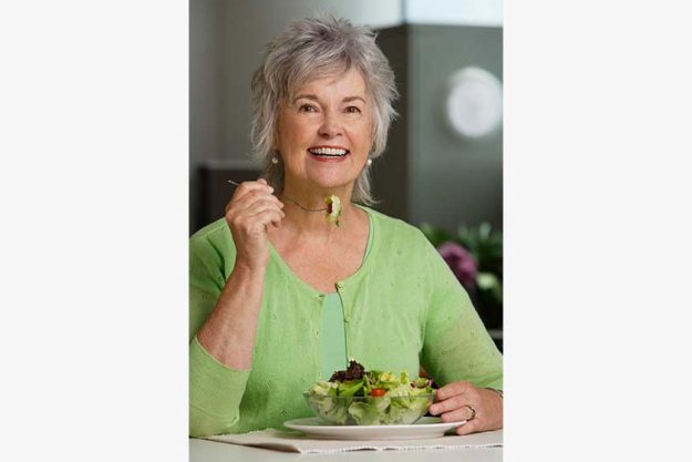 Mature woman eating salad Mature woman eating salad
