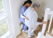 Nurse senior woman support stairs help walk nursing home caregiver
