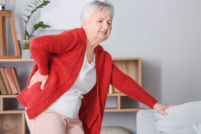 Senior woman suffering from back pain at home
