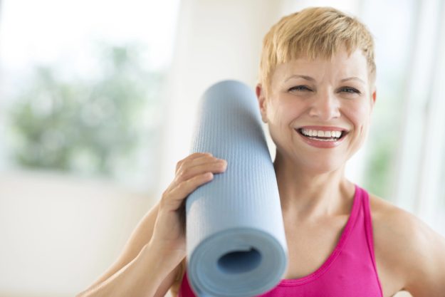 Cheerful Woman Holding Rolled Up Exercise Mat Cheerful Woman Holding Rolled Up Exercise Mat
