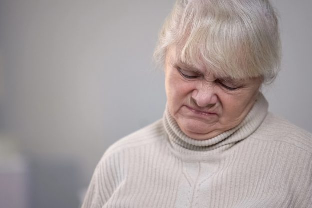 Elderly woman face close up with disgusting expression dementia health problem Elderly woman face close up with disgusting expression dementia health problem
