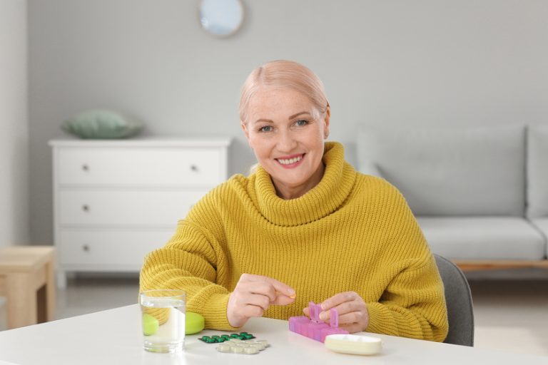 Mature woman taking pills at home