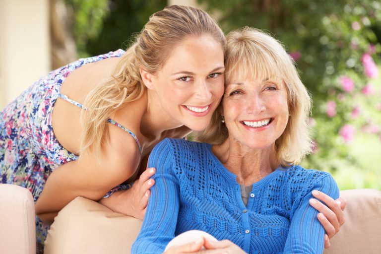 Senior Woman With Adult Daughter Relaxing On Sofa At Home Senior Woman With Adult Daughter Relaxing On Sofa At Home