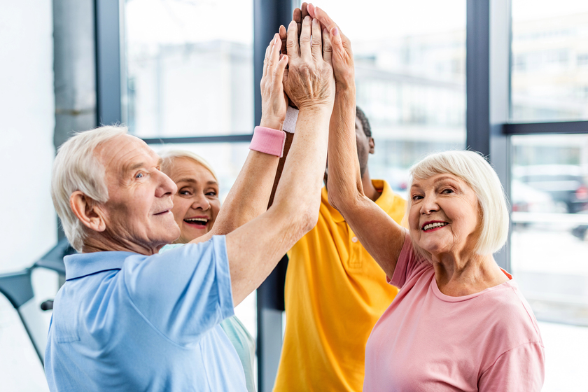 Senior happy multicultural sportspeople putting hands together at gym Senior happy multicultural sportspeople putting hands together at gym