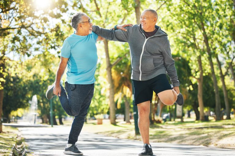 Senior man, friends and stretching in nature for running, exercise or outdoor training together at park. Mature people in body warm up, leg stretch or preparation for cardio workout or team fitness