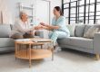 Senior woman taking bottle of water from physical therapist at home