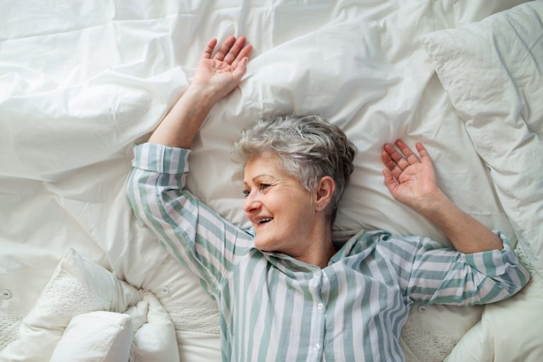 Top view of happy senior woman in bed at home, relaxing. Top view of happy senior woman in bed at home, relaxing.