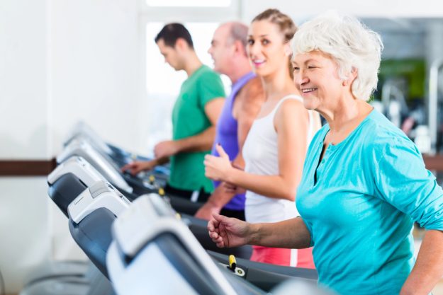 group with senior people on treadmill in gym