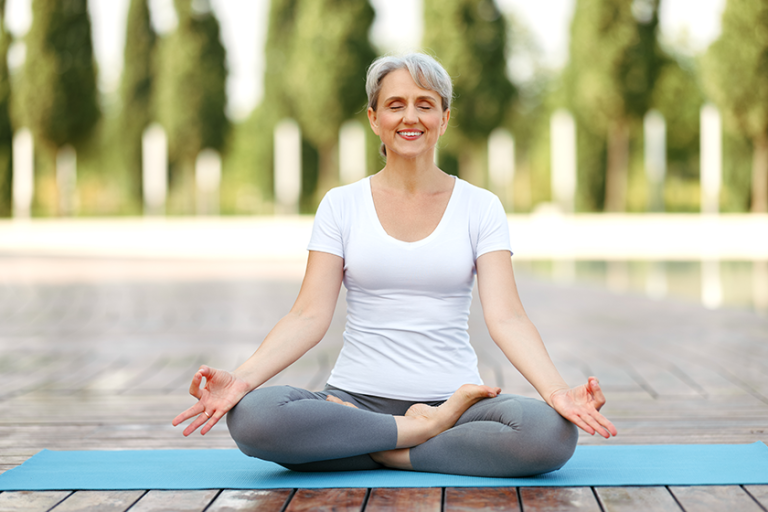 calm happy senior woman sitting in lotus pose