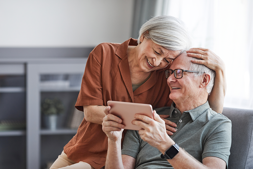 carefree senior couple using tablet