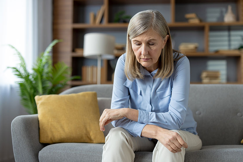 Elderly woman sits alone her sofa looking sad expression image Elderly woman sits alone her sofa looking sad expression image