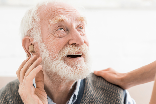 glad man hearing aid ear looking away