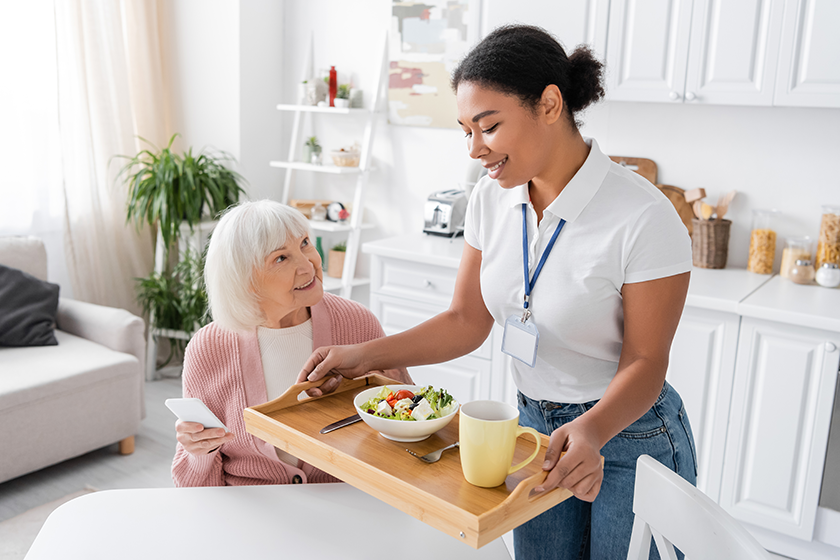 happy multiracial social worker holding tray