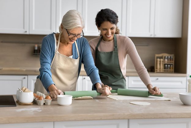 Happy senior mom adult daughter woman aprons cooking homemade pastry Happy senior mom adult daughter woman aprons cooking homemade pastry