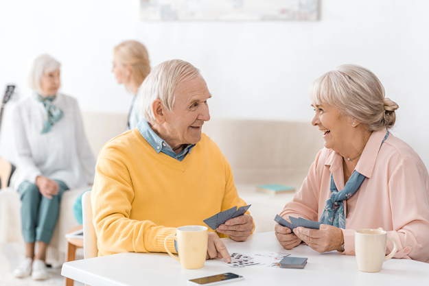 happy smiling senior couple playing cards