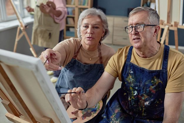 High angle portrait senior couple painting picture easel together art