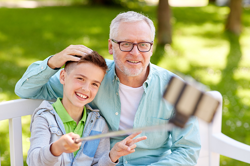old man and boy taking selfie by smartphone old man and boy taking selfie by smartphone
