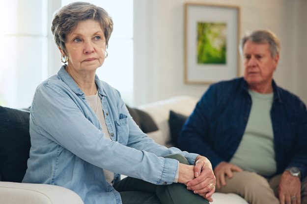 Senior couple angry conflict fight sofa living room home anger