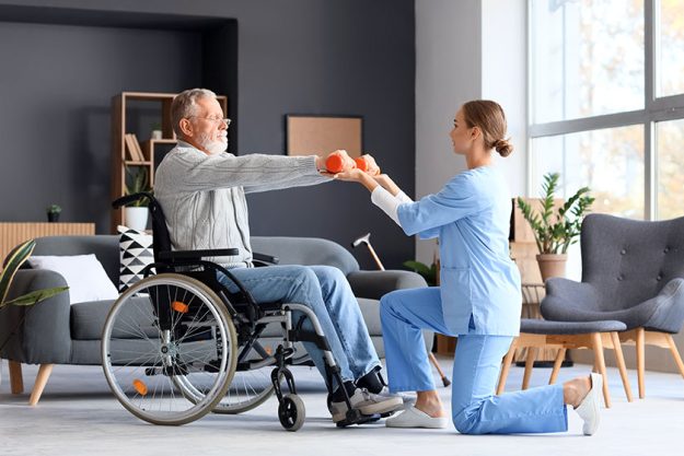 Senior man wheelchair dumbbells nurse training home Senior man wheelchair dumbbells nurse training home