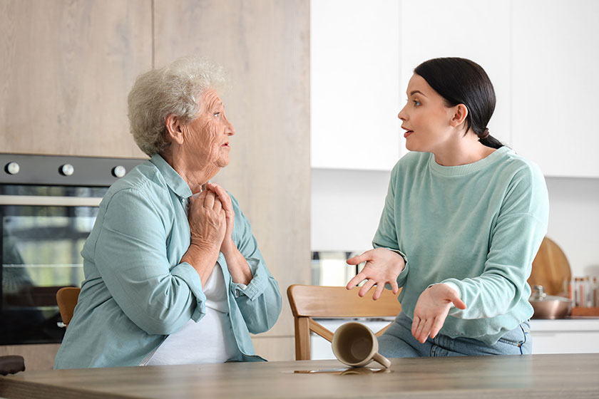 Senior woman her daughter upset spilled tea kitchen Senior woman her daughter upset spilled tea kitchen