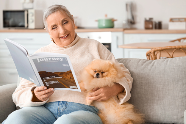 senior woman pomeranian dog reading magazine