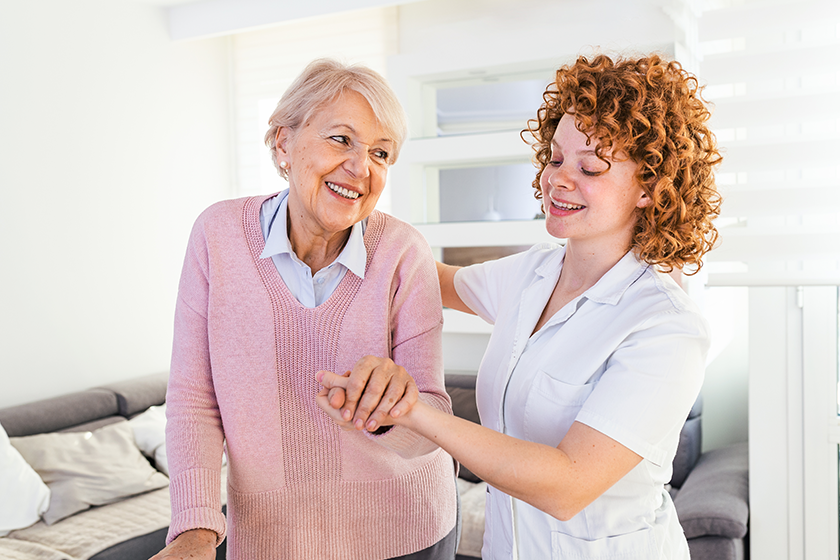 smiling nurse helping senior lady walk smiling nurse helping senior lady walk