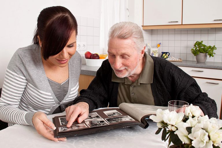 Woman looks at a photo album with seniors