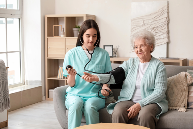 young caregiver measuring senior woman blood pressure
