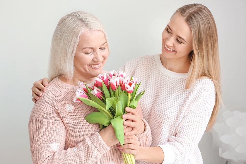 young daughter and mother with bouquet of flowers young daughter and mother with bouquet of flowers
