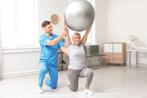 Physiotherapist working with patient in clinic rehabilitation therapy Physiotherapist working with patient in clinic rehabilitation therapy